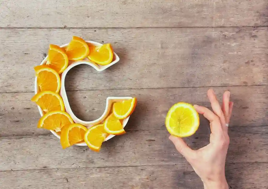 Vitamine pentru imunitate – Cele mai bune suplimente naturale pentru adulți Vitamina C pentru imunitate – felii de portocală în formă de C și o lămâie, surse naturale pentru întărirea sistemului imunitar