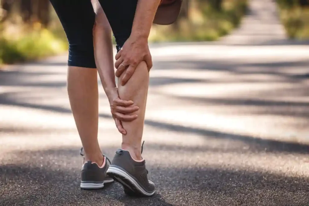 Persoană care suferă de dureri musculare la nivelul gambei în timpul mersului – posibile cauze și remedii naturale pentru relaxare musculară